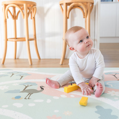 Baby with blocks on foam playmat