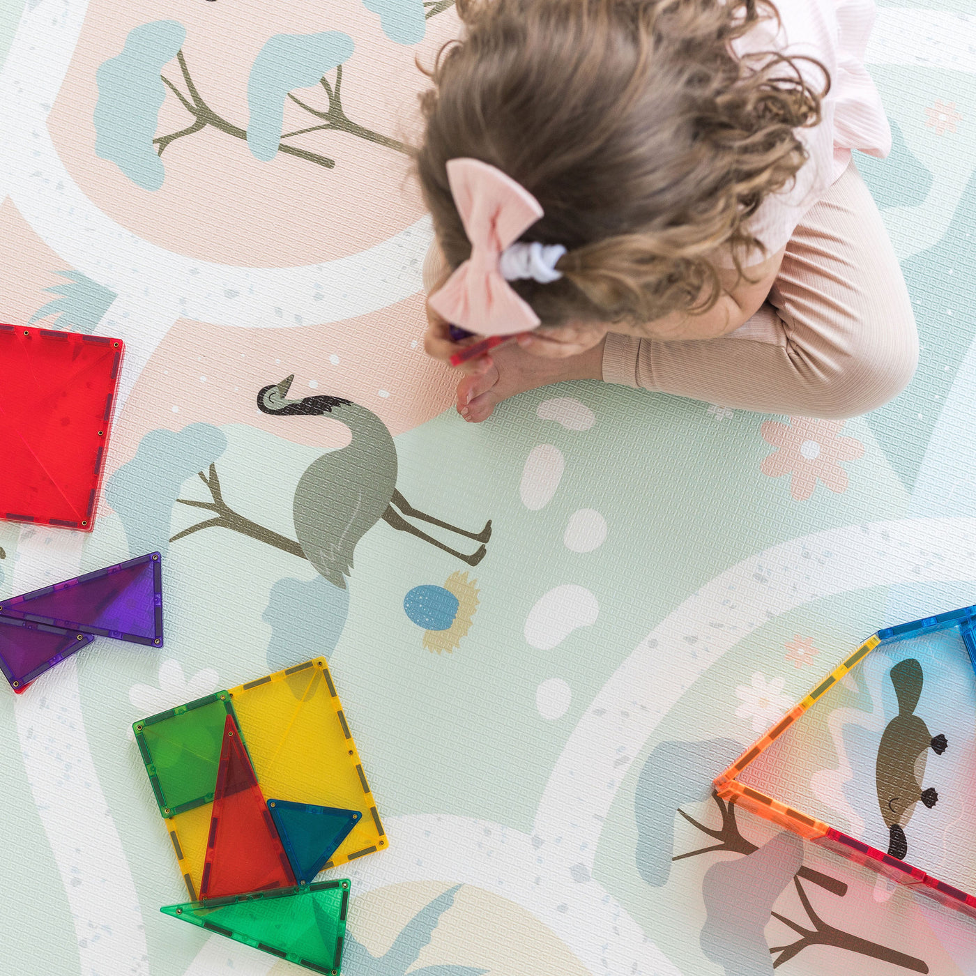 Girl playing with Connetix tiles on playmat