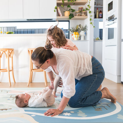 Family playing on foam playmat in kitchen