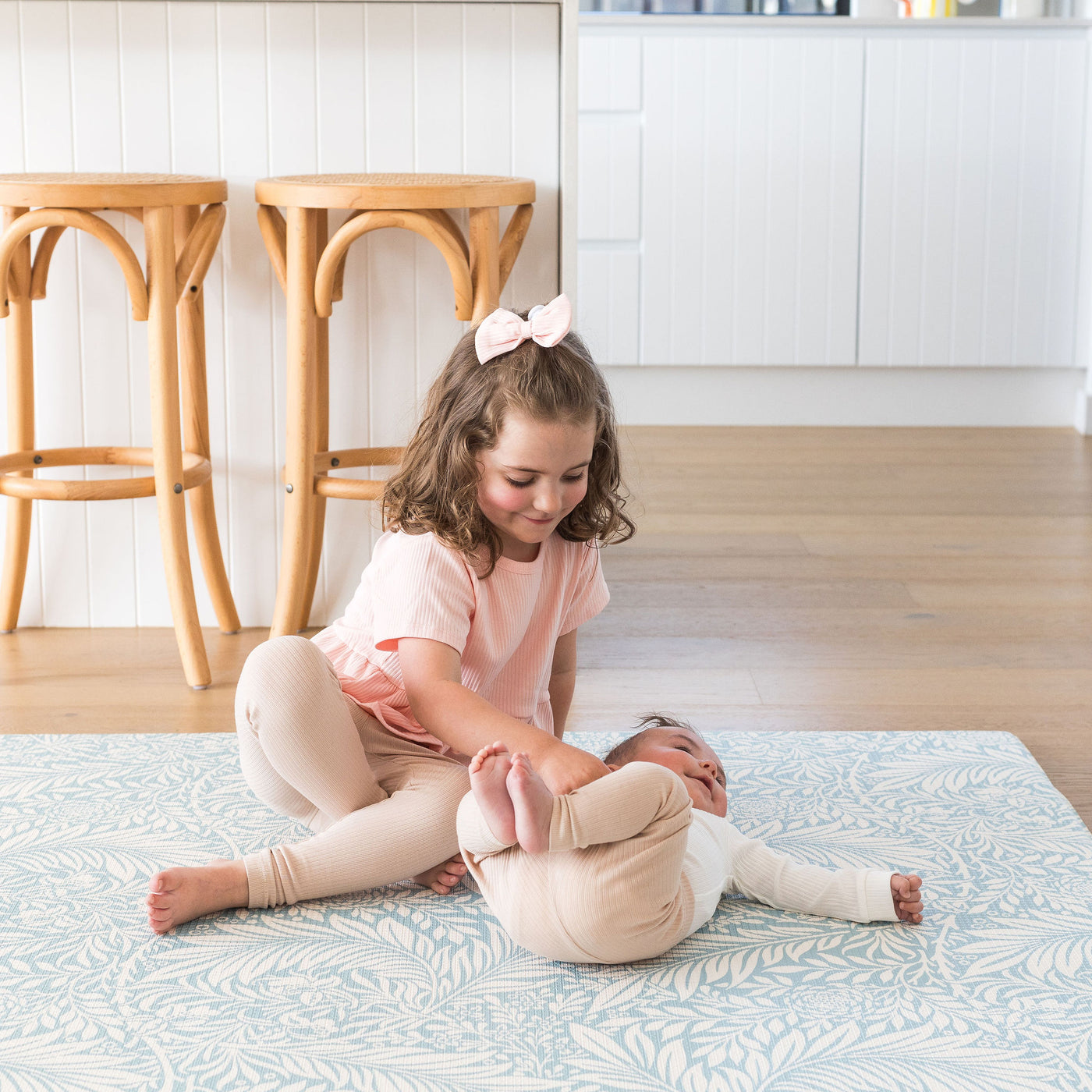 Siblings on nature playmat